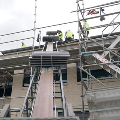 Digital home claims - front of house with builders working on the roof